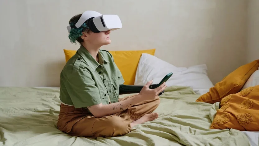 Person using a VR headset while holding a smartphone, representing modern digital platforms like Voozon.