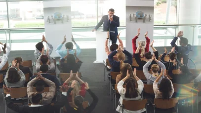 Confident speaker addressing a seated audience during a presentation, illustrating public speaking tips